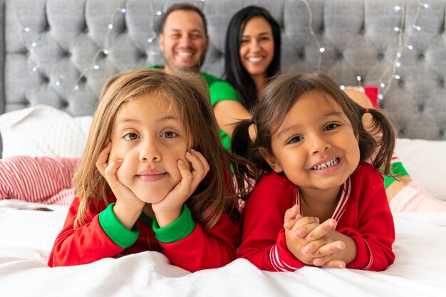 Nette Familie, die in ihrem Bett an Weihnachten liegt