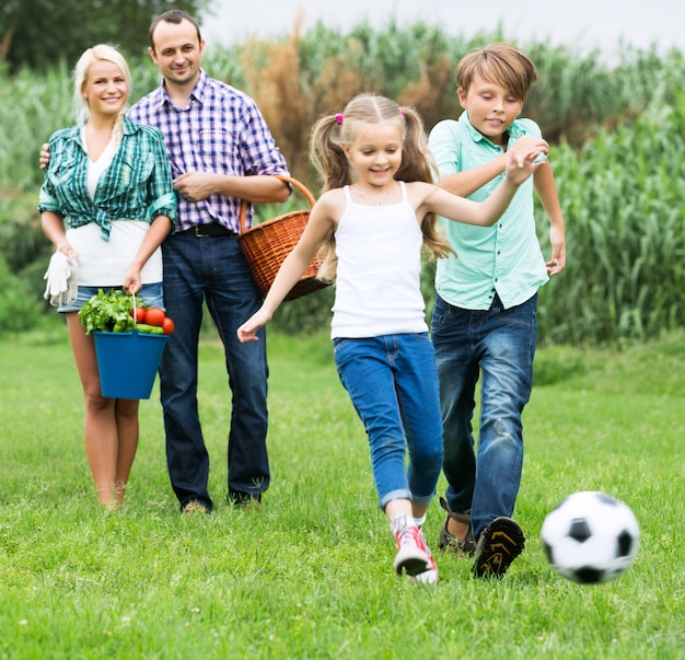 Foto nette familie, die mit ball läuft