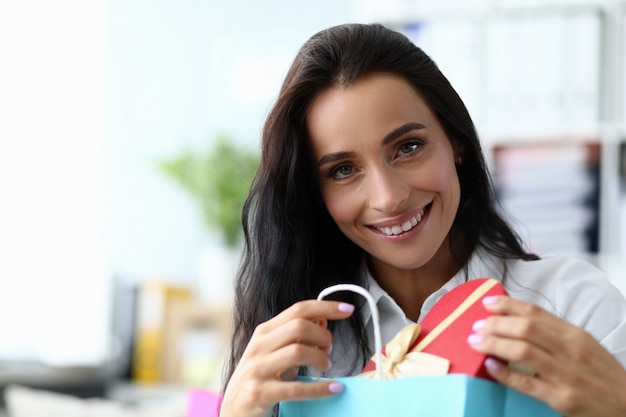 Nette Frau, die Geschenkbox hält