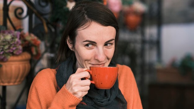 nette frau, die heißen kaffee in einem café trinkt