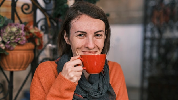 nette frau, die heißen kaffee in einem café trinkt