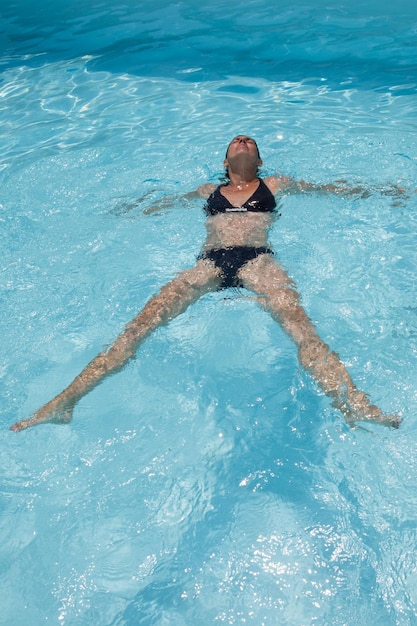 nette frau genießt wasserschwimmbad in den sommerferien