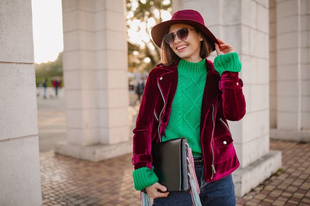 Nette Frau im trendigen Outfit im Herbststil, die auf der Straße spaziert