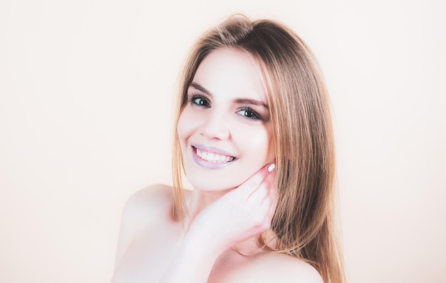 Nette Frau Lächelnde junge Frau, die über isoliertem Studiohintergrund nach oben schaut Schöne lächelnde Frau mit sauberer Haut, natürlichem Make-up und weißen Zähnen