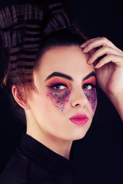 Nette Frau mit buntem Make-up. Kreatives Make-up und Frisur