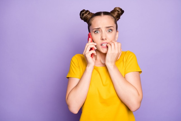 Nette Frau mit Haarknoten, die gegen die lila Wand aufwirft