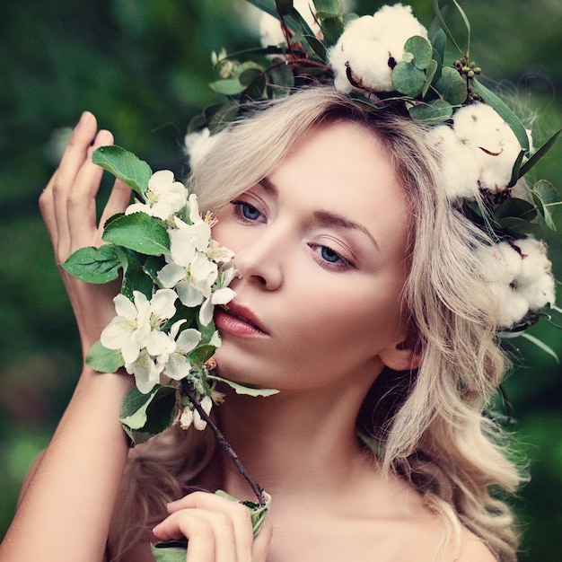 Nette Frau mit weißen Blumen Kranz im Freien. Natürliche Schönheit