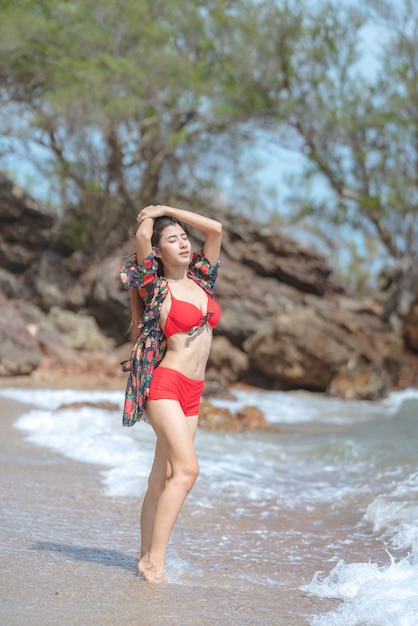 Nette junge asiatische Frau im Bikini glücklich am schönen Strand in den Sommerferien in Thailand