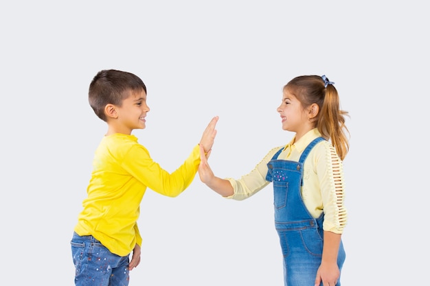 Nette Kinder auf einem weißen Hintergrund haben Spaß und spielen Lieblinge. Das Konzept der Emotionen und des Zeitaufwands von Kindern.