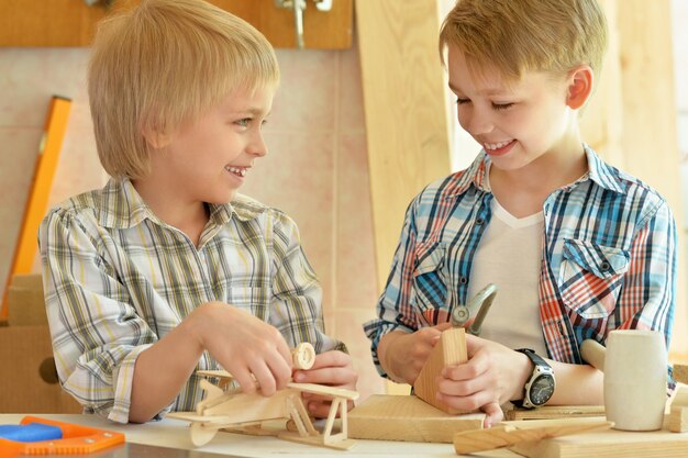 Nette kleine Jungs, die in der Werkstatt mit Holz arbeiten