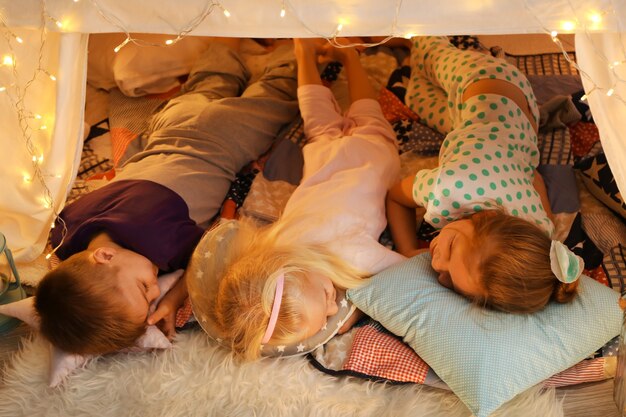 Nette kleine Kinder, die zu Hause in der Hütte schlafen sleeping