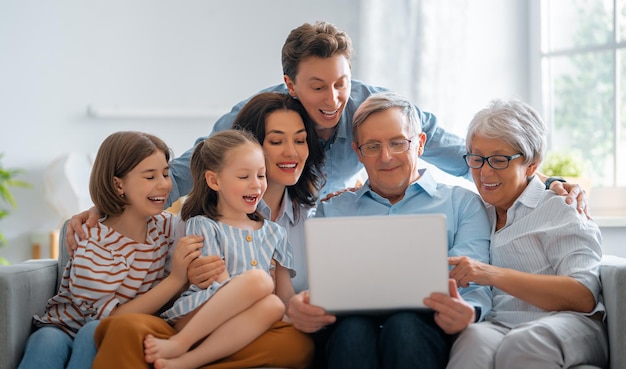 Nette Mädchen, ihre Mutter, ihr Vater, ihr Großvater und ihre Großmutter genießen die gemeinsame Zeit zu Hause. Familienzeit.