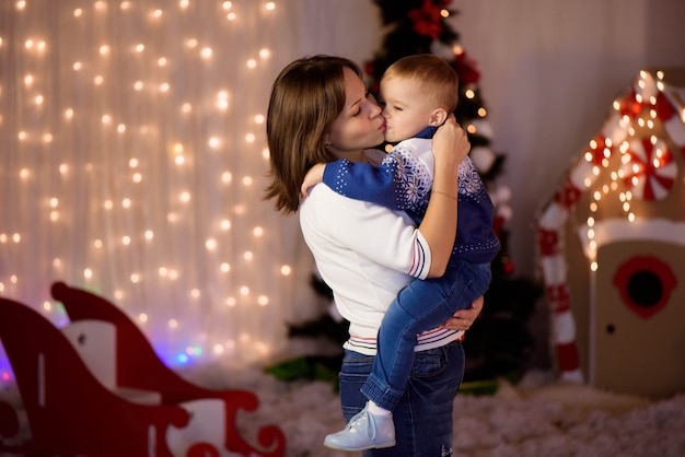 Nette Mutter und ihr netter Sohnjunge, die Spaß nahe Baum zuhause hat