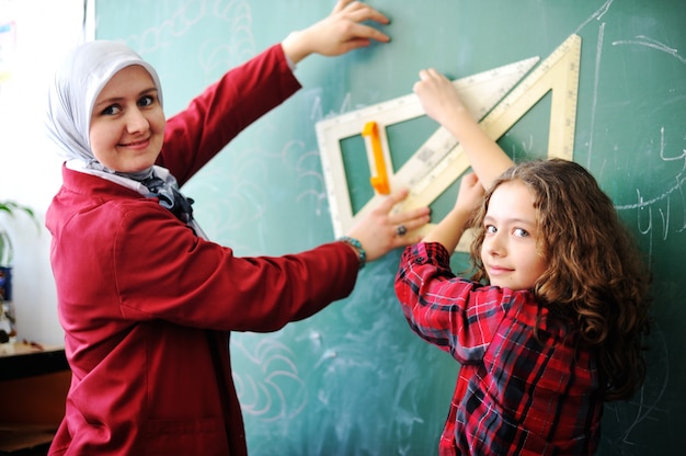 Nette reizende Schulkinder am Klassenzimmer, das Bildungsaktivitäten hat