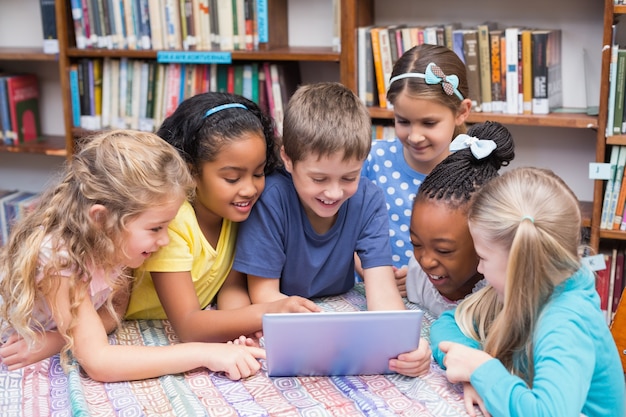 Nette Schüler, die Tablette in der Bibliothek betrachten