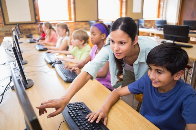 Nette Schüler in der Computerklasse mit Lehrer