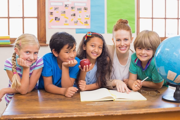 Nette Schüler und Lehrer, die an der Kamera im Klassenzimmer lächeln