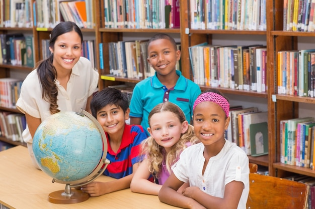 Nette Schüler und Lehrer, die Kugel in der Bibliothek betrachten