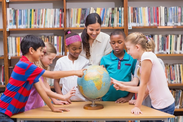 Nette Schüler und Lehrer, die Kugel in der Bibliothek betrachten