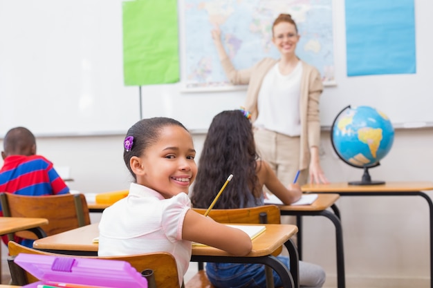 Nette Schüler und Lehrer im Klassenzimmer mit Kugel