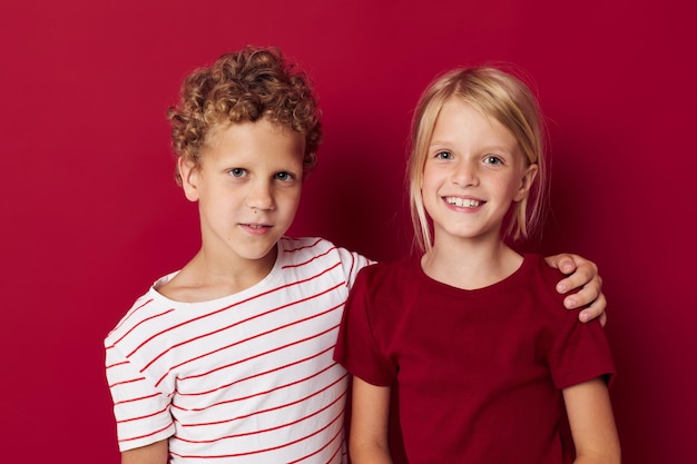 Nette stilvolle Kinder, die in Freizeitkleidung vor isoliertem Hintergrund lächeln und posieren