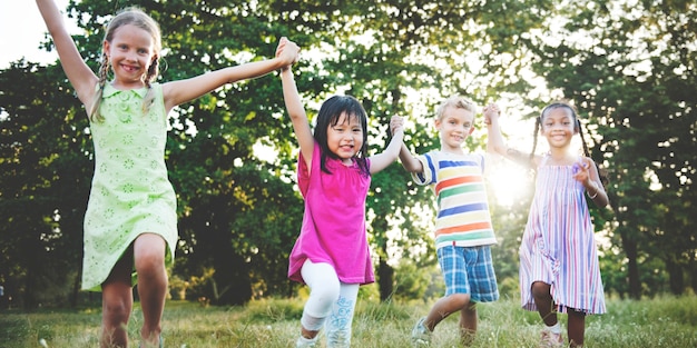 Nette verschiedene Kinder, die im Park spielen