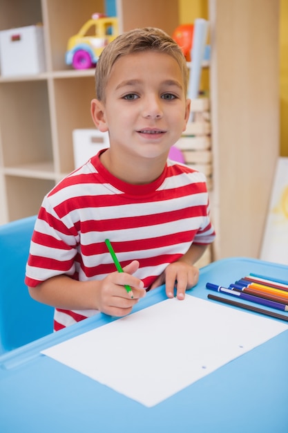 Nette Zeichnung des kleinen Jungen am Schreibtisch