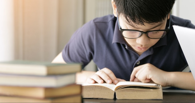 Netter asiatischer jugendlich Junge, der zu Hause Ihre Hausarbeit tut.