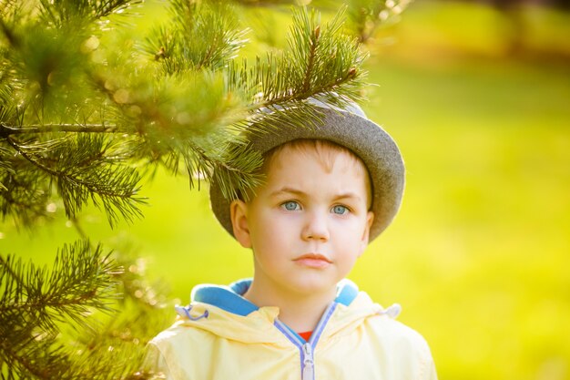 Netter blonder Junge nahe dem Baum