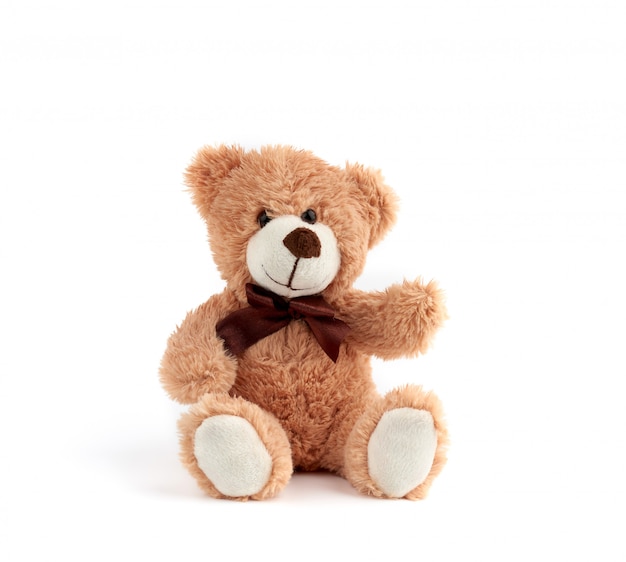 Netter brauner Teddybär mit einem Bogen um den Hals sitzen auf einem weißen Hintergrund
