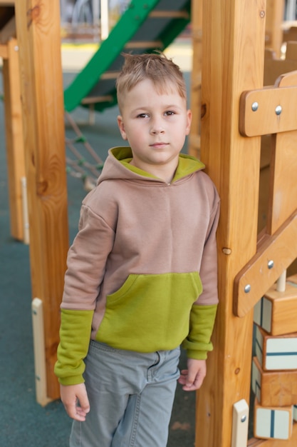 Netter frecher Vorschuljunge, der Spaß auf Spielplatz im Freien hat. Aktive Sportfreizeit im Frühling oder Sommer oder Herbst für Kinder. Outdoor-Aktivitäten für Familien mit Kindern