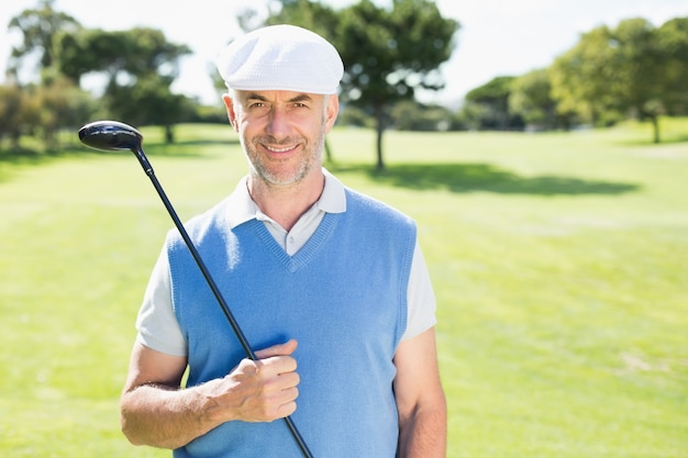 Netter Golfspieler, der an der Kamera lächelt