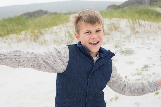 Netter Junge, der am Strand läuft