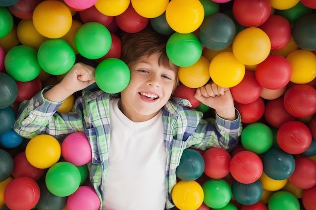 Netter Junge, der im Ballpool lächelt