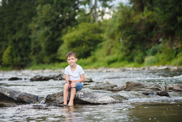 Netter Junge, der im Fluss fischt