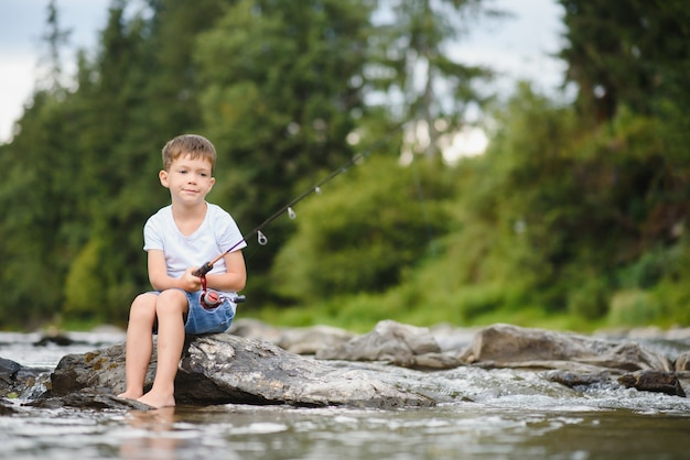 Netter Junge, der im Fluss fischt