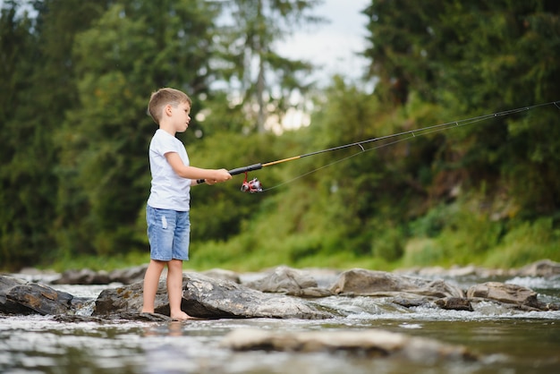 Netter Junge, der im Fluss fischt