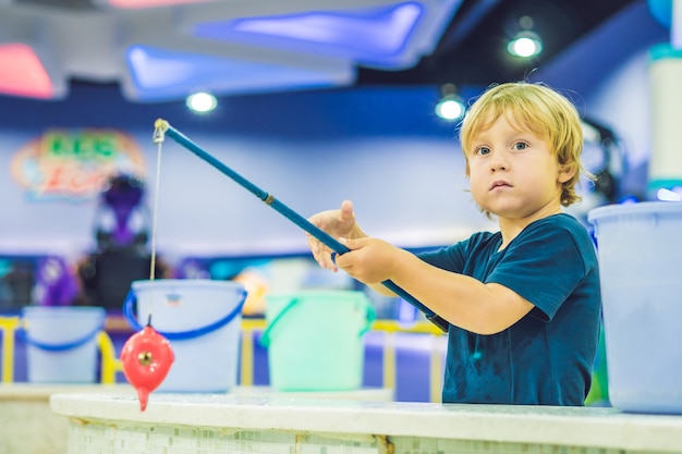 Netter Junge, der in einem Spielzimmer fischt