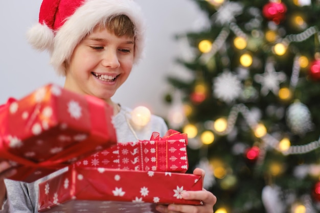 Netter Junge, der seine Geschenke an einem Weihnachtsmorgen hält