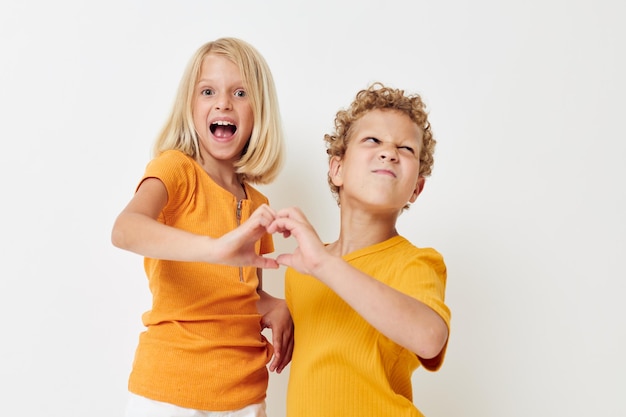 Netter Junge und Mädchen im Unterhaltungsstudio der gelben T-Shirts der Kindheit