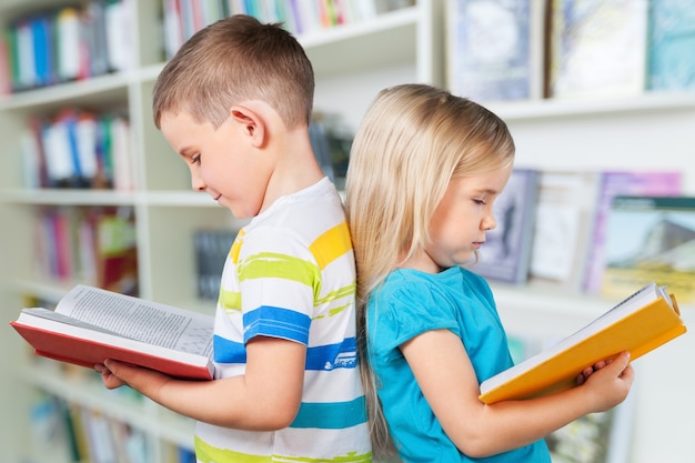 Netter Junge und seine kleine Schwester mit Büchern