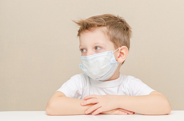 Netter Junge von vier Jahren in einer medizinischen Maske. Kinder unter Quarantäne wegen einer Epidemie.