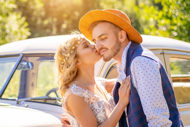 Netter Kerl und Mädchen nahe einem Auto an einem sonnigen Tag