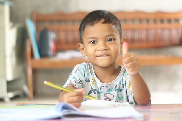 Netter Kinderjunge, der zu Hause studiert und denkt.