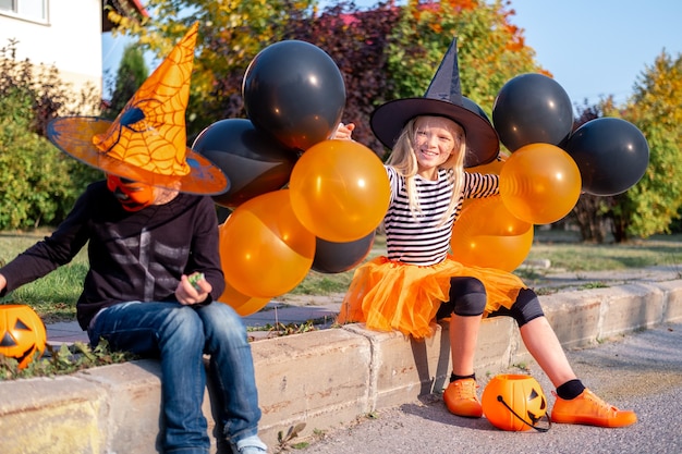 Netter kleiner Bruder und Schwester in Halloween-Kostümen