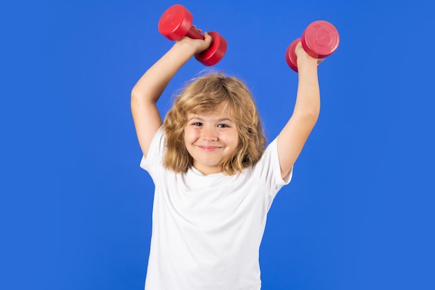 Netter kleiner Junge, der Übungen mit Hanteln macht Porträt eines sportlichen Kindes mit Hanteln Glückliches Kind, Junge, der gesunde Aktivitäten für Kinder ausübt