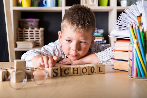 Netter kleiner Junge, der eine Schuluniform trägt