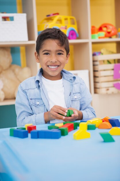 Netter kleiner Junge, der mit Bausteinen spielt