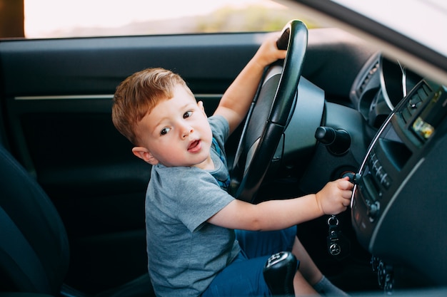 Netter kleiner Junge, der Vaterauto fährt