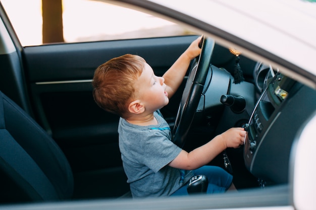 Netter kleiner Junge, der Vaterauto fährt